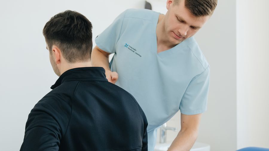 A physiotherapist assessing a patient with back pain
