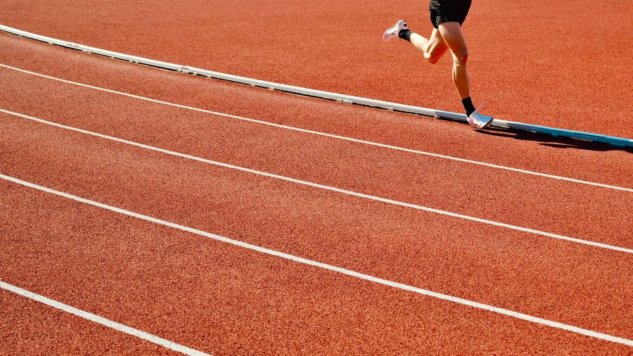 A runner training on an outdoor athletics track